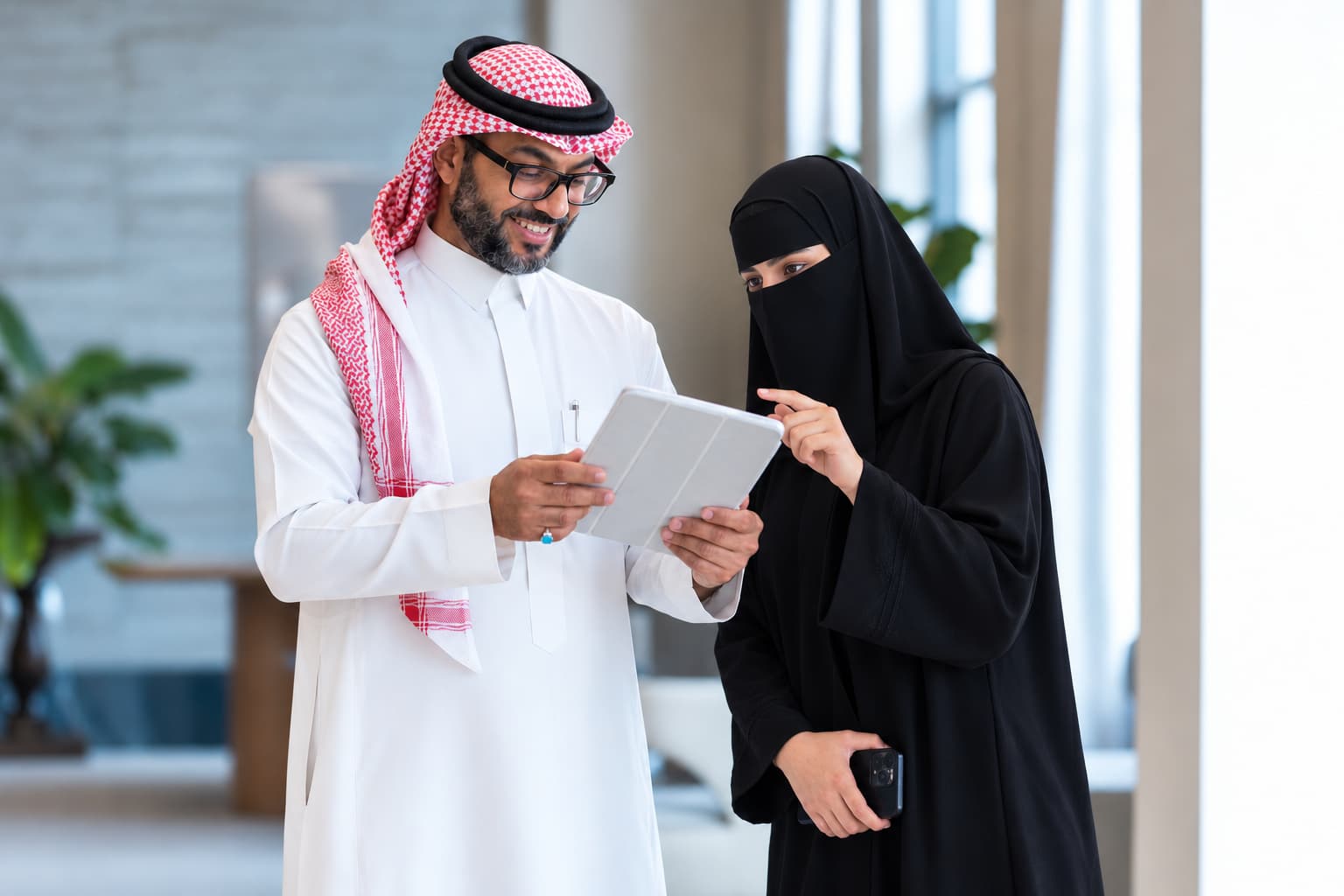 زميلان يراجعان مستندًا على جهاز لوحي في المكتب